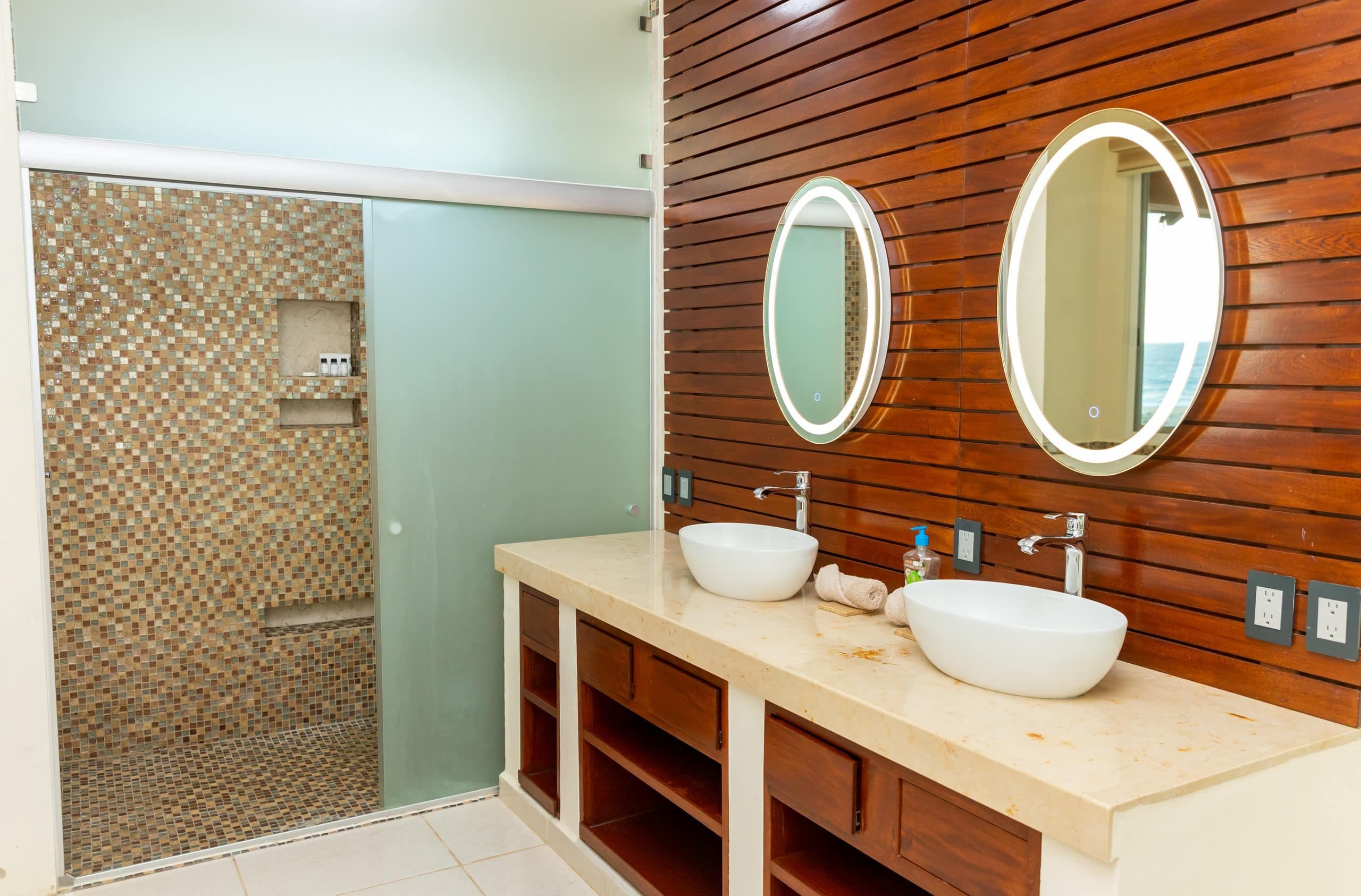 Baño con doble lavabo y muro de madera