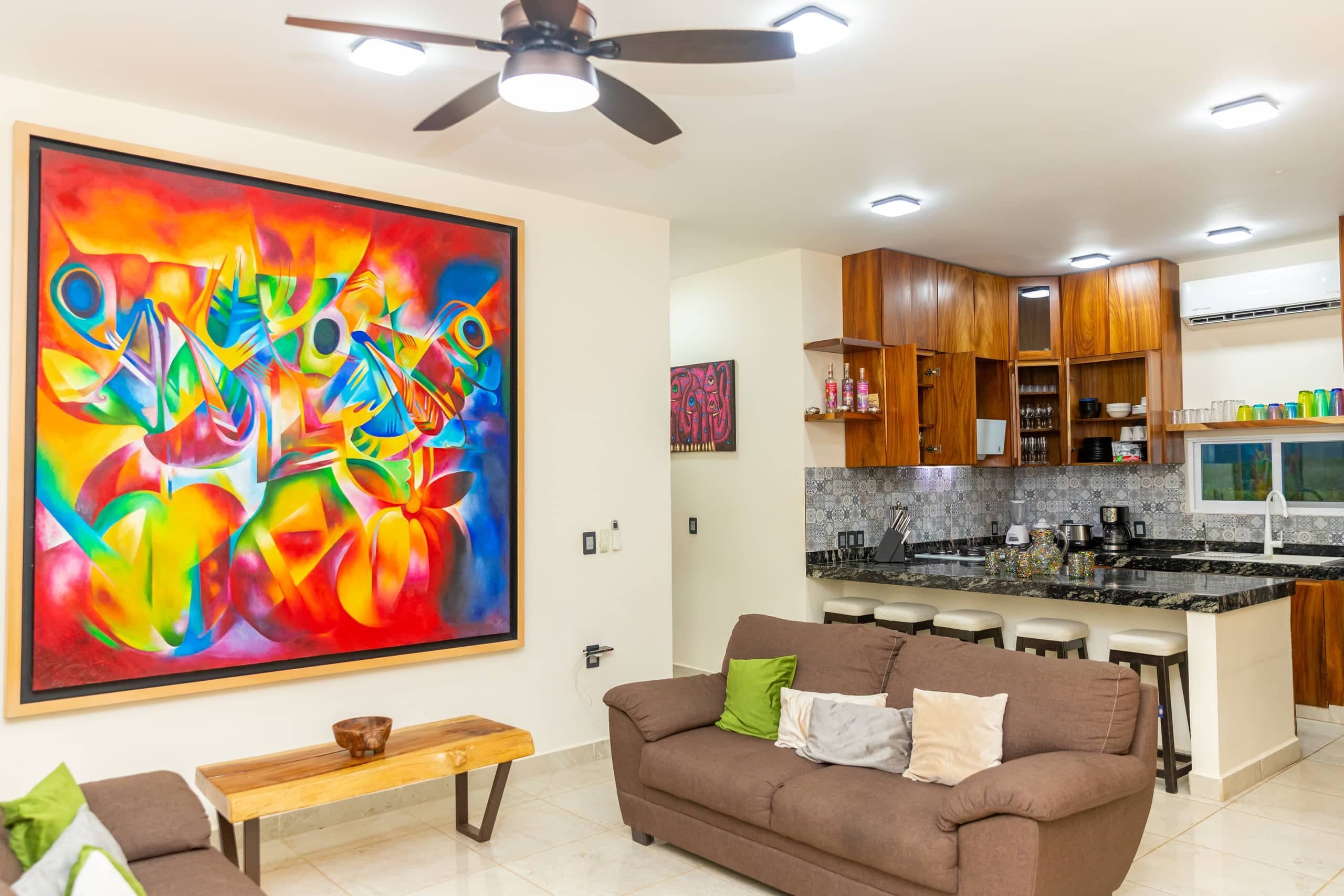 Sala de Casa Colores con arte de colores intensos y muebles de madera local